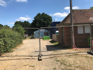 the old pavilion and scout hut surrounded by a fence
